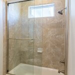 Framed sliding glass shower doors in tiled bathroom