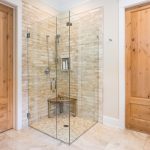 A beautiful bathroom with a custom-built corner frameless glass shower enclosure
