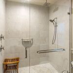 Modern bathroom with custom frameless glass shower door with brushed nickel handles and hardware