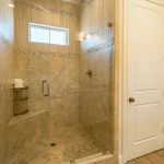 Bathroom with glass frameless shower with custom tiling and built-in bench